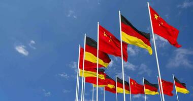 Tyskland och Kina flaggor vinka tillsammans i de himmel, sömlös slinga i vind, Plats på vänster sida för design eller information, 3d tolkning video