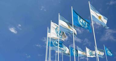 Argentine et uni nations, ONU drapeaux agitant ensemble dans le ciel, sans couture boucle dans vent, espace sur la gauche côté pour conception ou information, 3d le rendu video