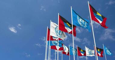 antigua et Barbuda et uni nations, ONU drapeaux agitant ensemble dans le ciel, sans couture boucle dans vent, espace sur la gauche côté pour conception ou information, 3d le rendu video