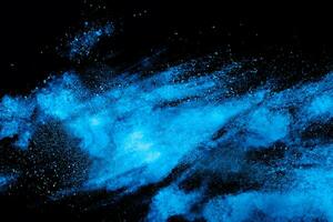 Blue powder explode cloud on black background. Launched blue dust particles splash on  background. photo