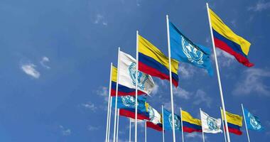 Colombie et uni nations, ONU drapeaux agitant ensemble dans le ciel, sans couture boucle dans vent, espace sur la gauche côté pour conception ou information, 3d le rendu video