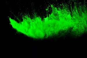 Green color powder explosion cloud on black background.Green dust splash. photo