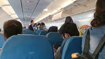 Narita, Japan on September 28, 2023. Airplane passengers queue to get off the plane. Several passengers were seen taking their belongings in the cabin, and the flight attendant greeted them video