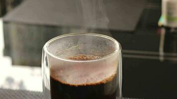 lento movimento cenas do a transparente copo do quente cheio de vapor café. bebida video