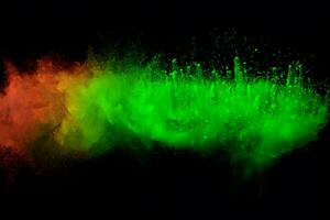 Green color powder explosion cloud on black background.Green dust splash. photo