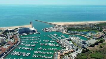 Aerial drone point of view of Vilamoura City and Harbour. Situated in South of Portugal is a famous travel destination. Drone forward descending, tilt down video
