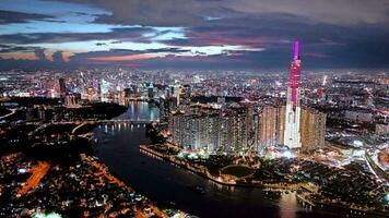 Aerial sunset view at Landmark 81 - it is a super tall skyscraper and Saigon bridge with development buildings along Saigon river light smooth down video