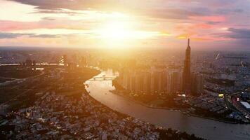 Aerial sunset view at Landmark 81 - it is a super tall skyscraper and Saigon bridge with development buildings along Saigon river light smooth down video