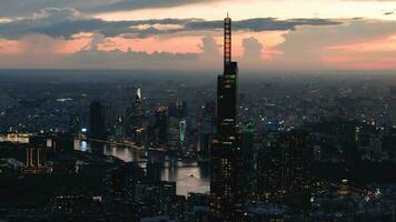 Aerial sunset view at Landmark 81 - it is a super tall skyscraper and Saigon bridge with development buildings along Saigon river light smooth down video