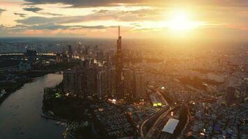 Aerial sunset view at Landmark 81 - it is a super tall skyscraper and Saigon bridge with development buildings along Saigon river light smooth down video