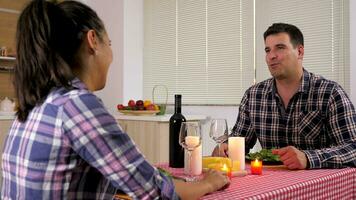 homme ayant bougie lumière dîner avec le sien petite amie dans le cuisine à maison. chariot glissière 4k métrage video