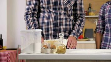 Couple in the living room preparing dough for baking. Close up dolly slider 4K slow motion footage video