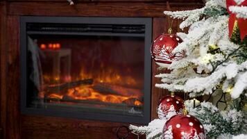 Christmas decorated red glass balls on a tree near a beautiful fireplace. Holiday season. Static shot video