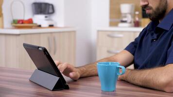 Close up footage of nan surfing the web on a digital tablet PC in his kitchen at the table video