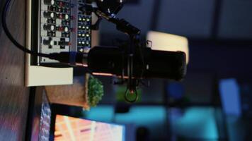 Vertical video Close up shot of microphone used for podcasts, vlogging and livestreams on vlog channel. Zoom in on professional mic in dimly lit studio used for recording audio during internet show