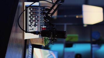 Vertical video Panning shot of podcast microphone used to record discussions for internet livestreaming channel and 3D renders running on notebook screen. High tech streaming sound capturing and recording devices