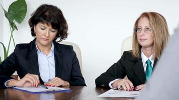 Revealing shot of businesswoman signing a contract at the desk in the meeting room. Dolly slider 4K footage video