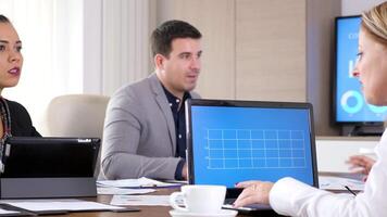 Businesswoman in conference room talking with her colleague while on a laptop is displaying an animated data analysis. Dolly slider 4K footage video