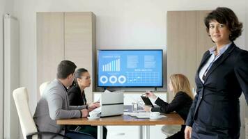 Confident businesswoman smiling in slow motion in front of her team in conference meeting room video