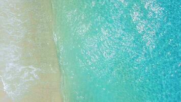 Man run on beach and jump to the blue sea. Summer vacation on tropical island. Aerial view video