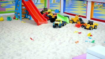 arena y vistoso juguetes en un patio de recreo adentro. video