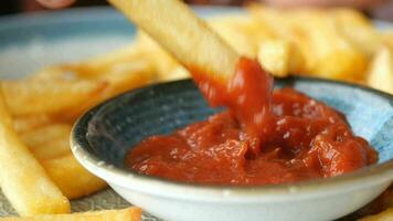 dettaglio tiro di francese patatine fritte sorseggiando salsa su tavolo video