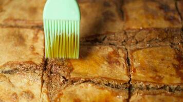 Applying honey to surface of cake with silicone brush, close-up. video