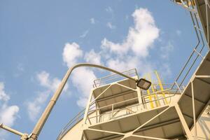 plate form on the service water tank with blue sky. The photo is suitable to use for industry background photography, power plant poster and maintenance content media.