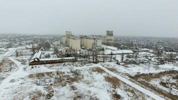 Grain terminal in the winter season. Snow-covered grain elevator in rural areas. A building for drying and storing grain. photo