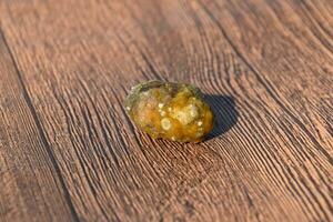 Stone of gallbladder. The result of gallstones. A calculus of dissimilar composition on a wooden background. photo