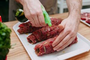 Cooking meat rolls in the cooking class. Beef roll. Raw meat, close-up, hands in the frame. photo