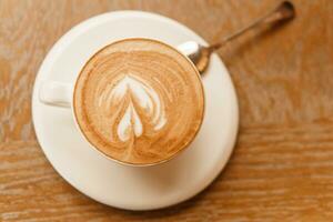 capuchino en un taza en el mesa foto