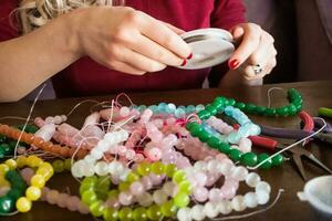 Beads of semiprecious stones. Lots of beads. Sort and select beads. photo