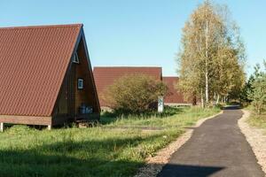 el concepto de glamping y alquiler un chalet para fin de semana. de madera casa con un veranda en naturaleza alrededor conífero arboles foto