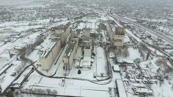 Grain terminal in the winter season. Snow-covered grain elevator in rural areas. A building for drying and storing grain. photo