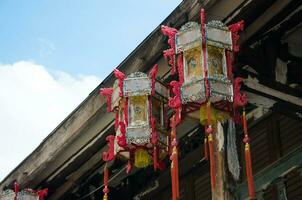 Chinese Lanterns Hanging On The Roof of Old Wood House photo