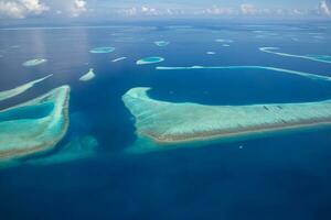 Tropical islands and atolls in Maldives from aerial view. Maldives tourism. photo