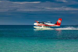 gemelo nutria rojo hidroavión aterrizaje a Maldivas. lujo viaje transporte en tropical maldivo Oceano laguna. exótico verano destino escénico. sur ari atolón, dhidhoofinolhu, Maldivas - 15.12.21 foto