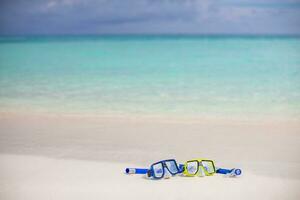 deporte de verano, actividad en la playa pancarta recreativa en la playa. gafas de buceo equipo de snorkel en arena blanca cerca de las olas del mar. vacaciones panorámicas y antecedentes de viajes recreativos. diversión libertad aventura estilo de vida foto