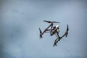 Drone flying against blue sky with copy space. Modern technology UAV with camera use for photo or video