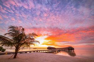 Amazing beach landscape. Beautiful Maldives sunset seascape view. Horizon colorful sea sky clouds, over water villa pier pathway. Tranquil island lagoon, tourism travel background. Exotic vacation photo