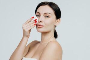 Portrait of a young attractive woman cleaning her face with a cotton pad isolated over white background. Perfect Fresh Skin. Pure Beauty Model. Care Concept. photo