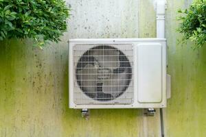 aire acondicionador compresor al aire libre unidad instalado en sucio hormigón pared fuera de el casa o oficina. foto