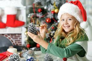 contento niña en Papa Noel sombrero sentado con Navidad presente foto