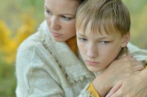 triste madre con hijo en un caminar en parque foto