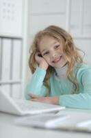 Cute and happy little girl children using laptop computer photo