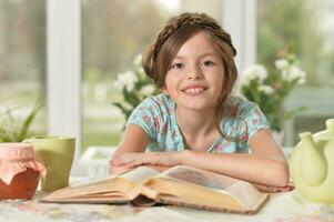 Close up portrait of young girl reading interesting big book photo