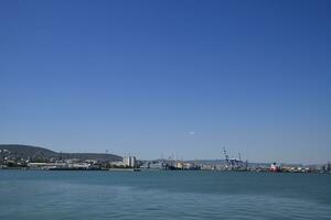 Cargo port with port cranes. Sea bay and mountainous coast. photo