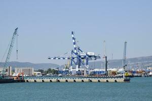 Cargo port with port cranes. Sea bay and mountainous coast. photo