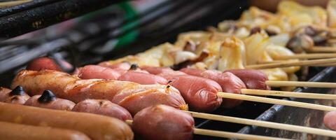 Sausages and Squid are Grilling on the open fire outside, Grilling Food, Charcoal grilling. photo